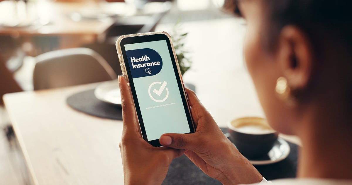 Person using a mobile phone to access healthcare coverage and benefits